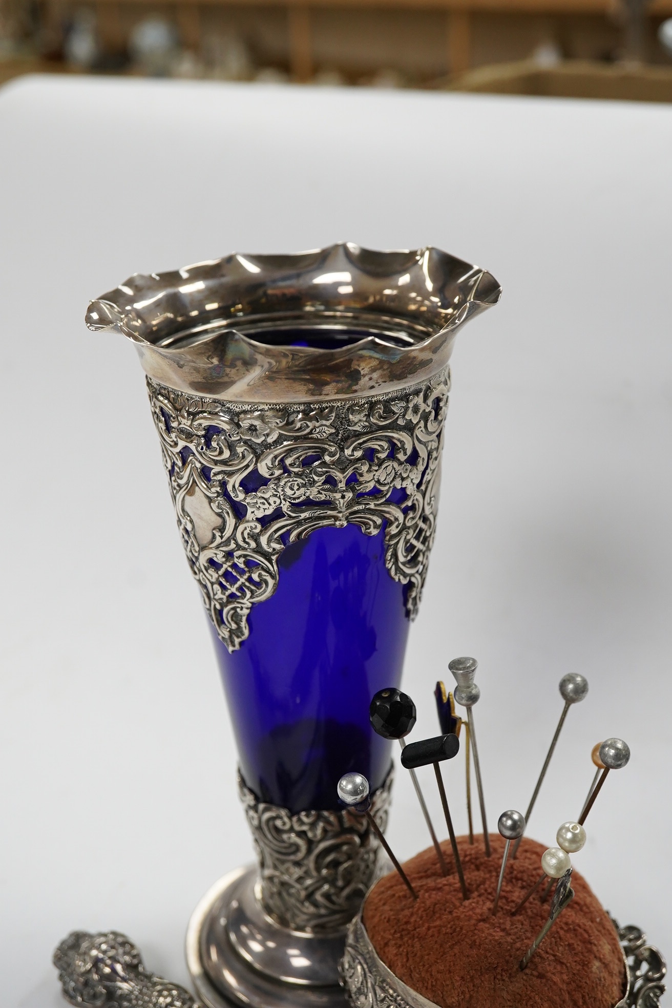 A small group of assorted silver items including mounted blue glass spill vase, 17.2cm, mounted shoe horn and button hook and a trinket dish, together with two other items. Condition - poor to fair